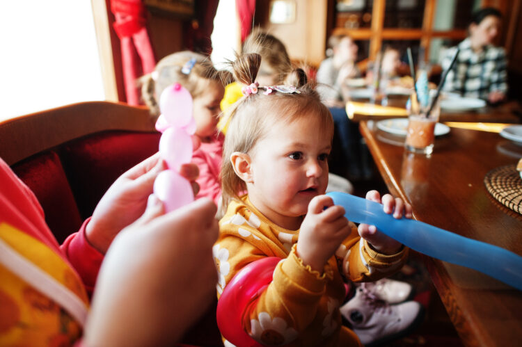 Children at birthday party make balloons animals.